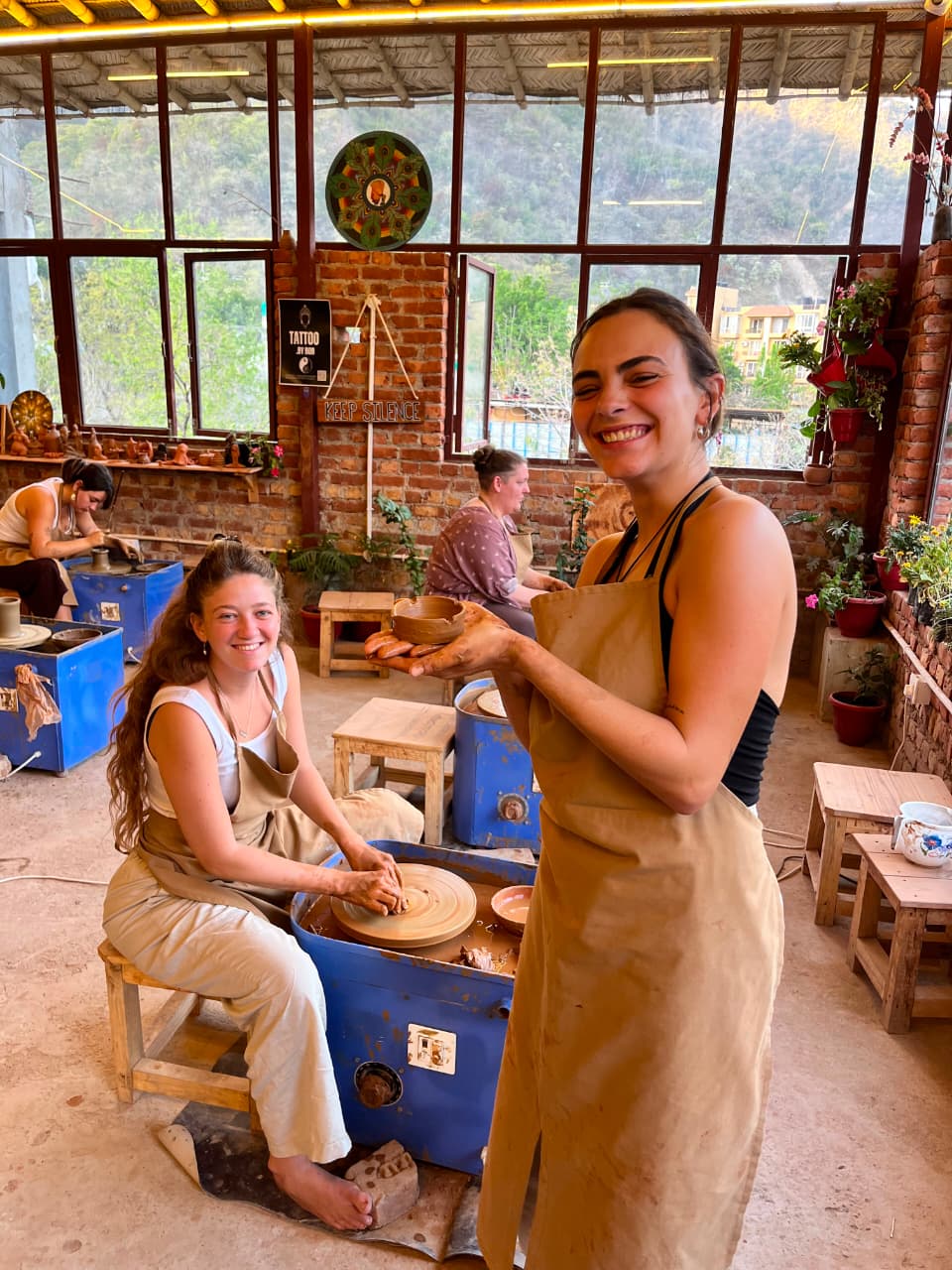 Guests smiling during a pottery wheel session