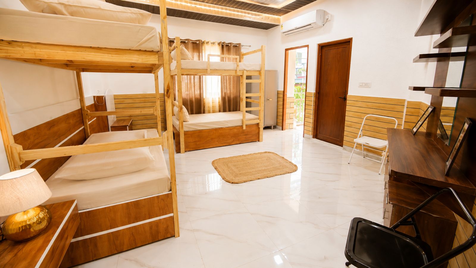 Dorm bunk room with desk, chair, and multiple bunks