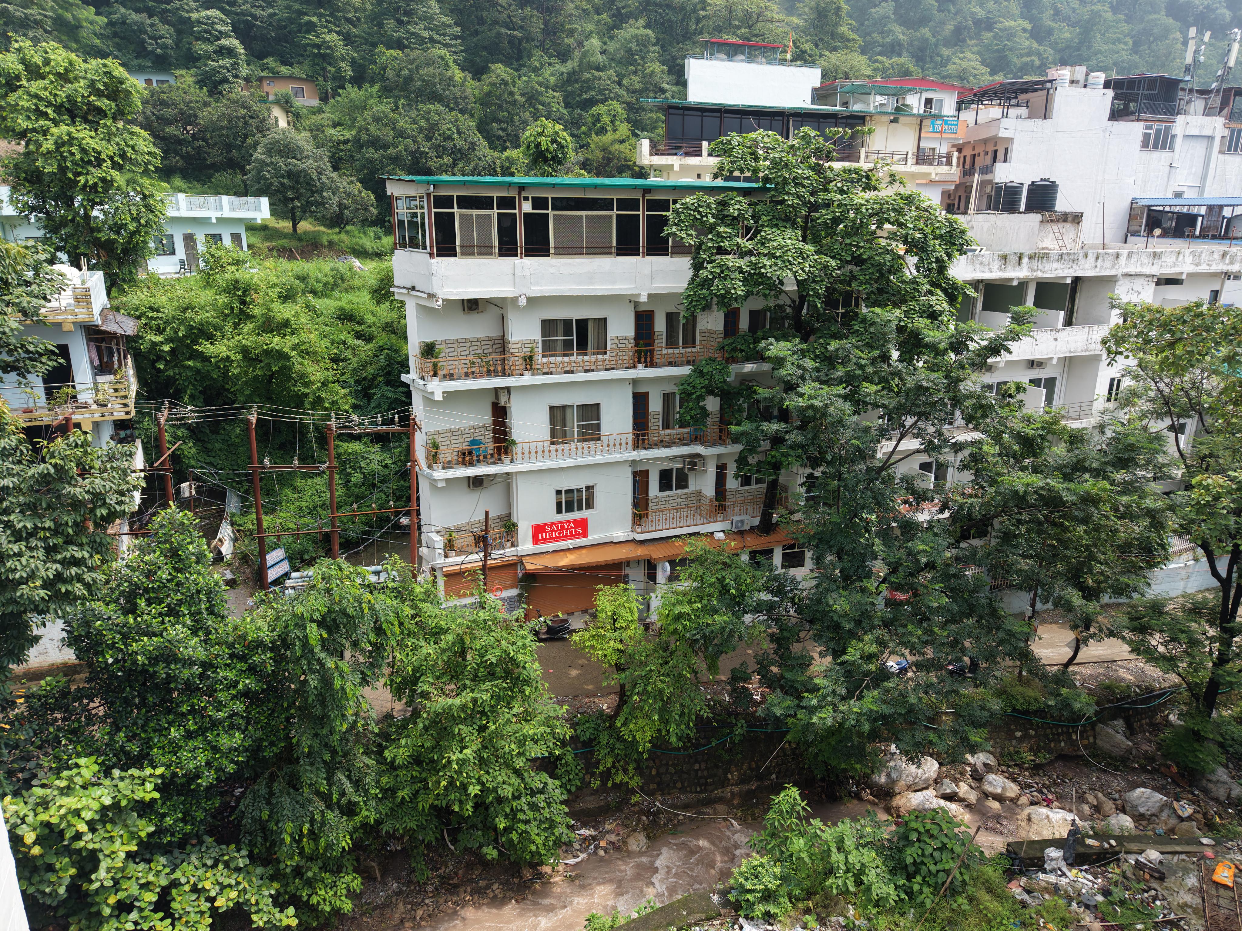 Exterior drone view of Lily's Retreats building surrounded by Tapovan greenery